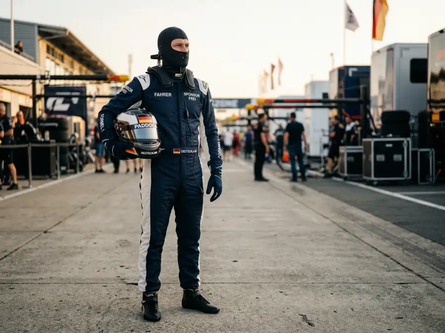 Formel-1-Pilot in Rennoverall mit Helm im Fahrerlager vor dem Rennen