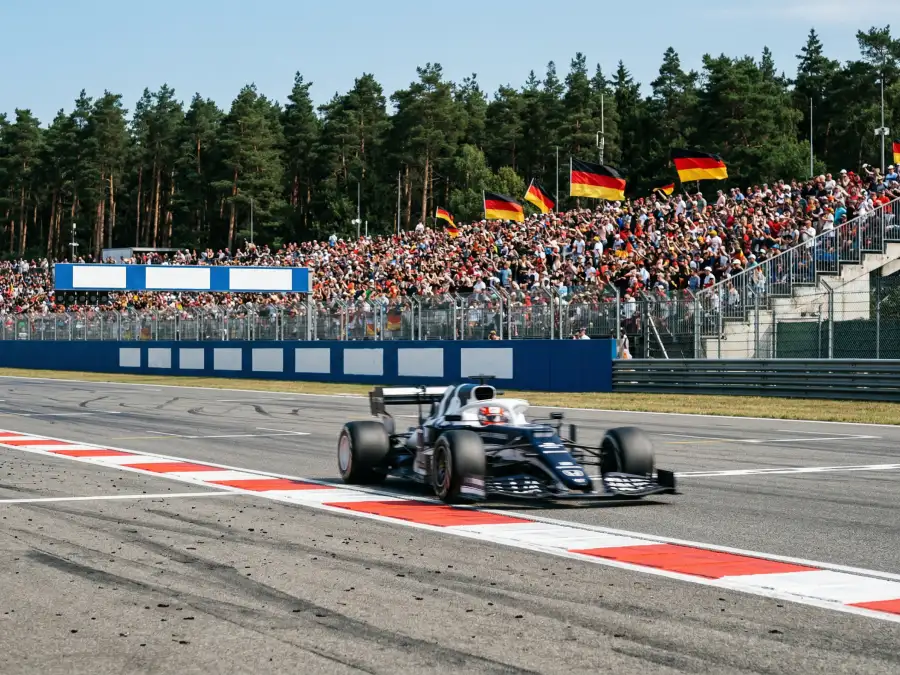 Formel-1-Rennstrecke in Deutschland mit voller Zuschauertribüne und Rennwagen auf der Start-Ziel-Geraden