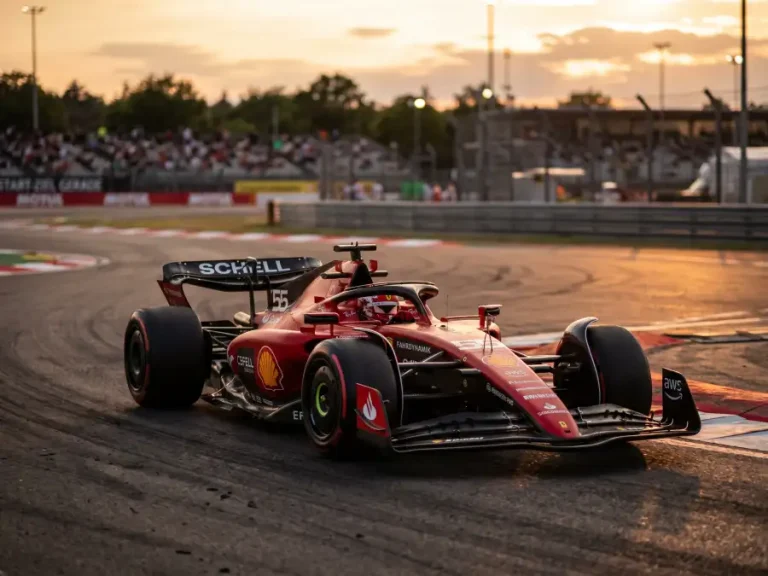 Formel-1-Bolide in Ferrari-Rot auf der Rennstrecke beim Sonnenuntergang während eines Trainings