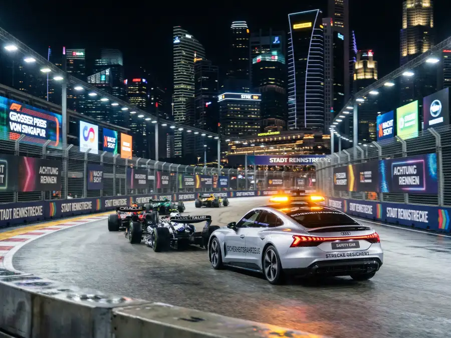 Safety Car mit Rundumleuchte führt Feld von Formel-1-Wagen auf dem beleuchteten Marina-Bay-Stadtkurs in Singapur bei Nacht an
