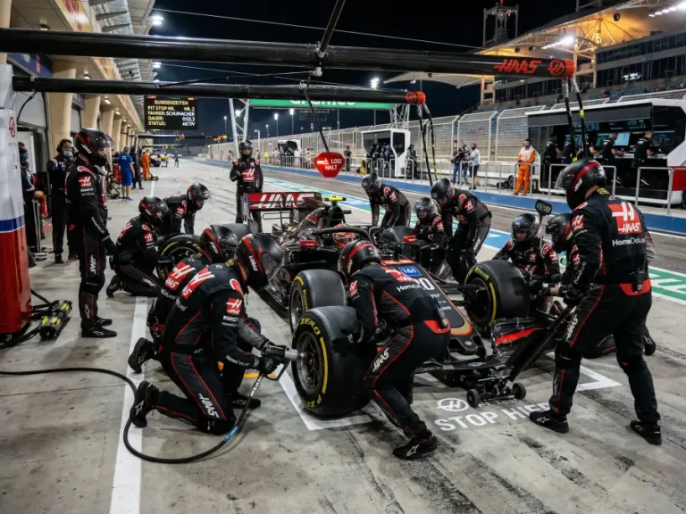Formel-1-Rennwagen in der Boxengasse während eines Boxenstopps mit Team-Mechanikern